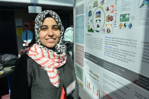 Malak standing by her poster at the University of Ottawa poster competition. She won the IEEE First Place award