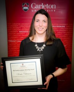 Sonia standing with her certificate for the Graduate Mentoring Award
