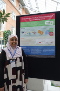 Sana standing next to her poster at IDC 2018