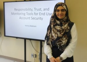 Yomna standing in front of her title slide from her Master's thesis defence