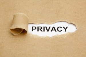 The word Privacy appearing from behind a torn piece of brown paper