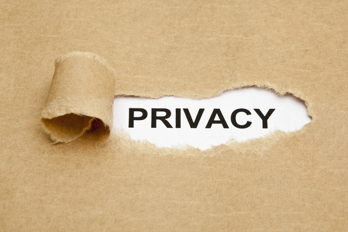 The word Privacy appearing from behind a torn piece of brown paper.