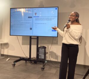 Charlotte standing next to a large screen, presenting her research